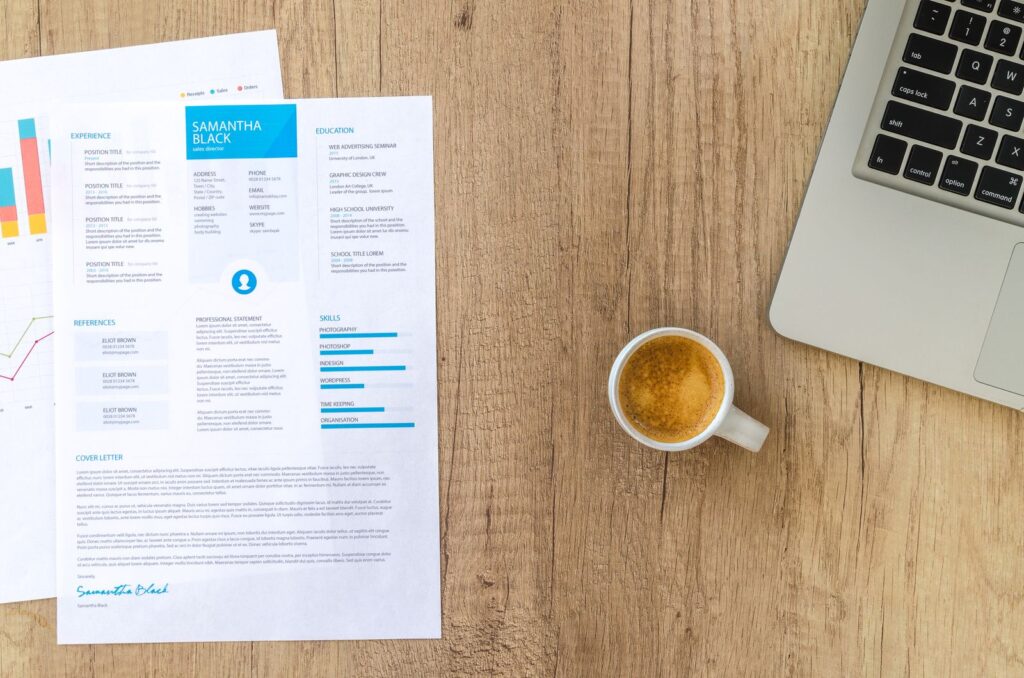 Desk with a resume, laptop and coffee