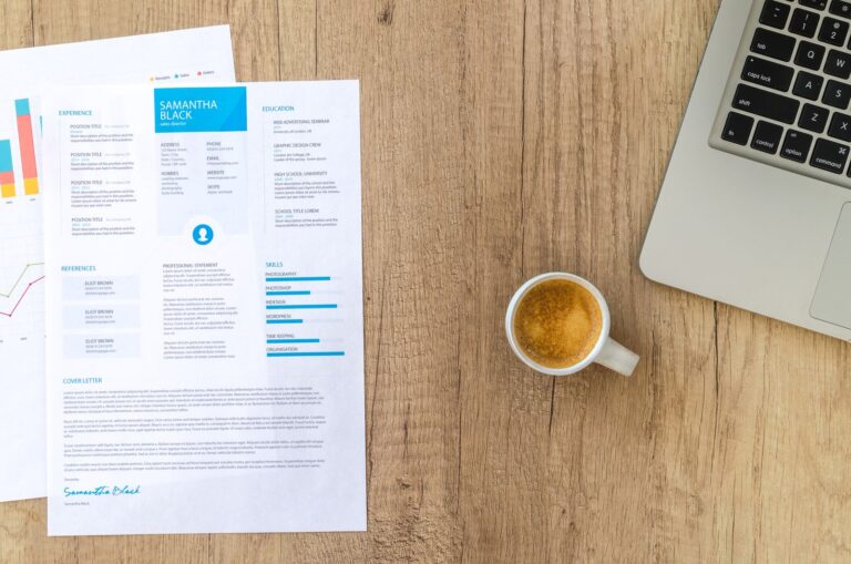 Desk with a resume, laptop and coffee