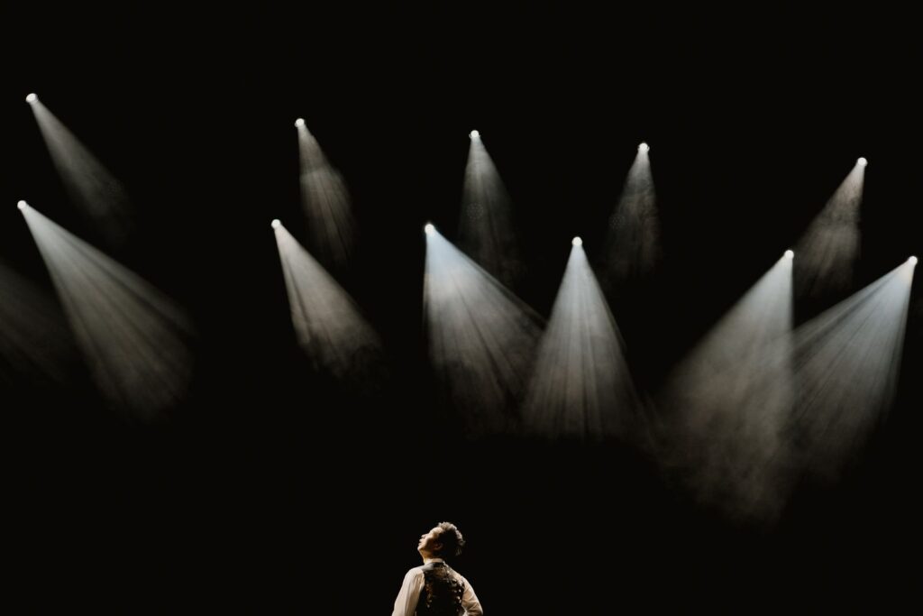 Solo performer in a spotlight on a dark stage